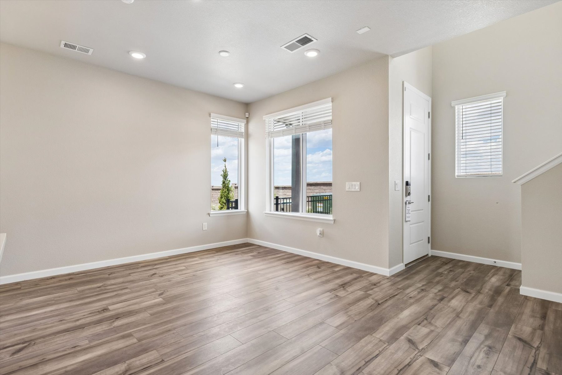 A room with a wood floor and a wood floor with a window.