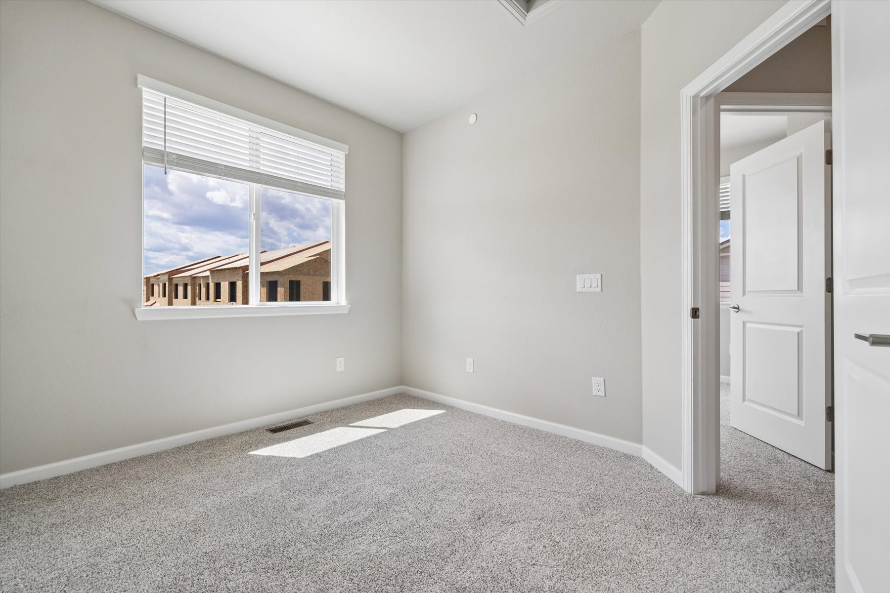 A room with a window and a rug.
