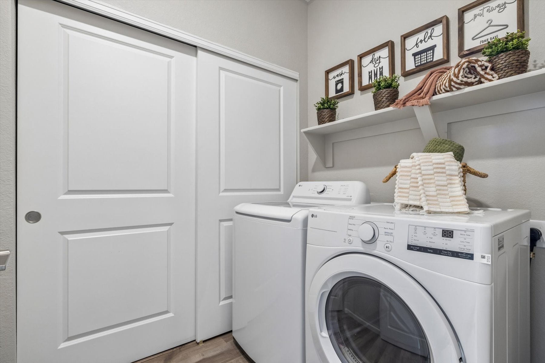 A white laundry room with a white washer and dryer.
