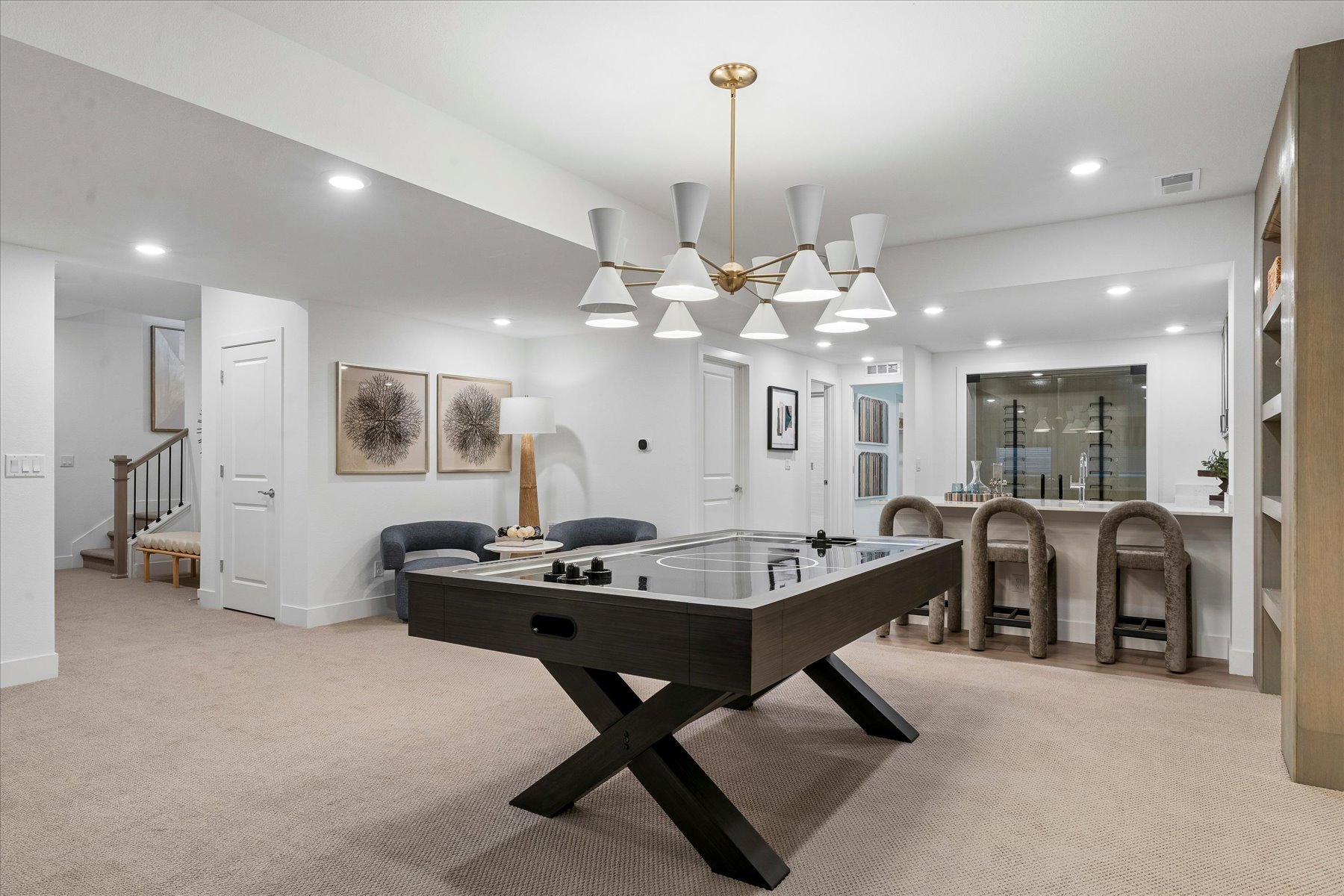 A room with a pool table and chairs.