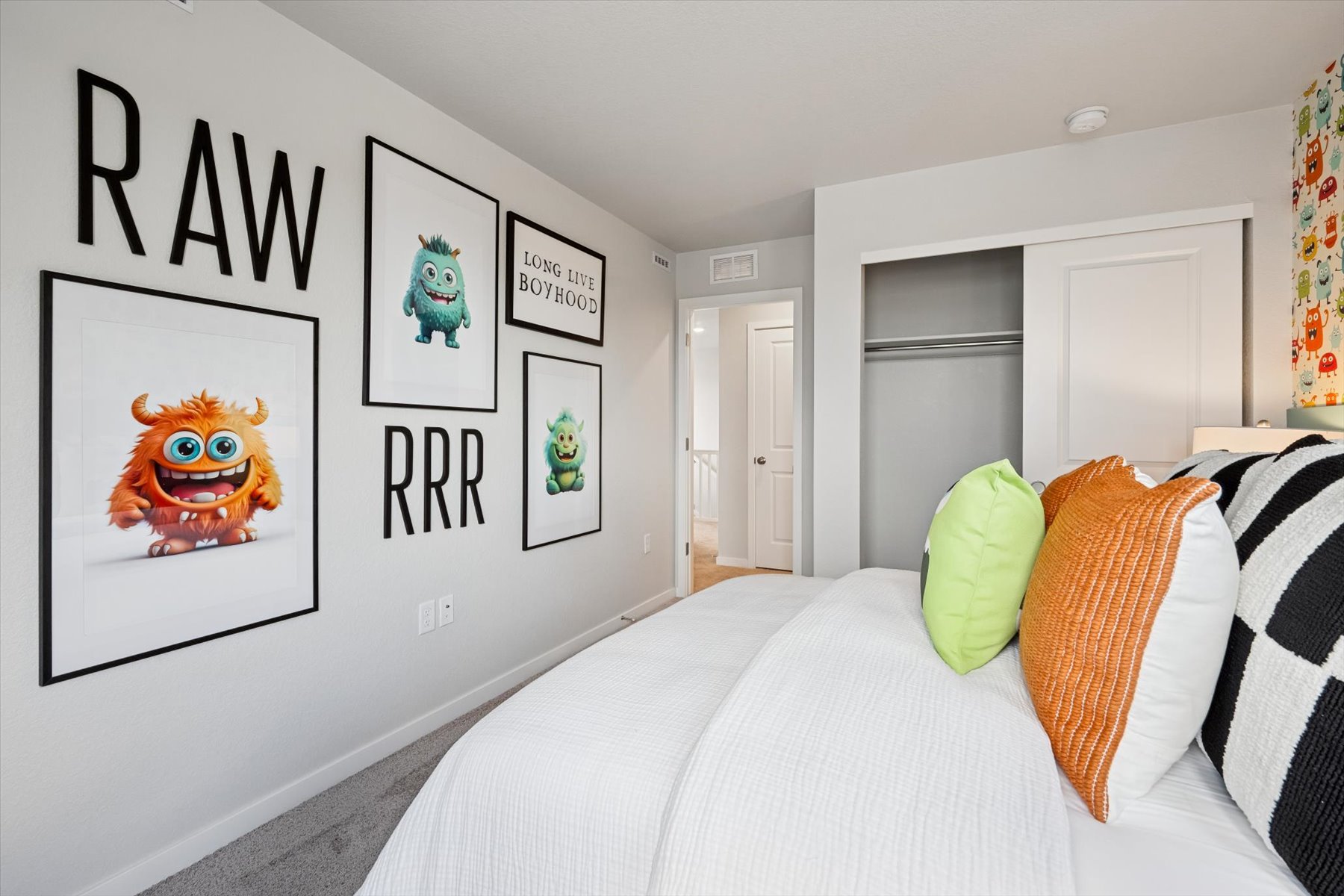 A room with a bed and a wall with pictures on it.