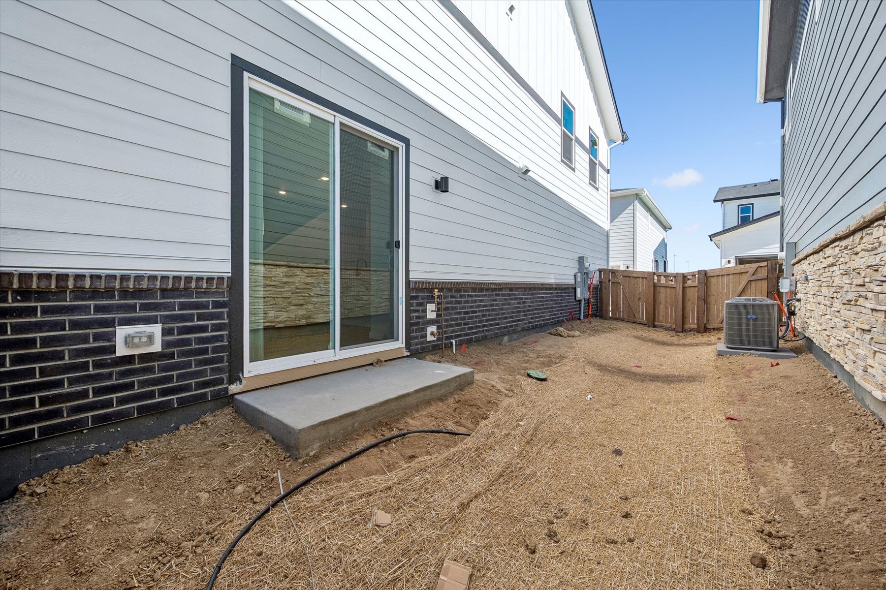 A building with a fence and a dirt yard.