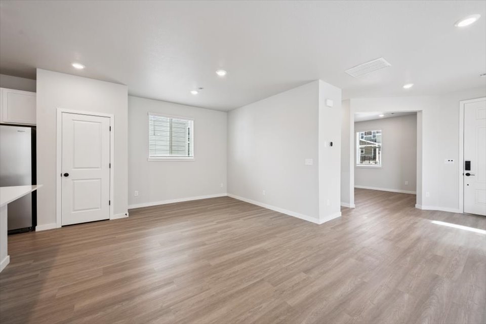 A room with white walls and wood floors.