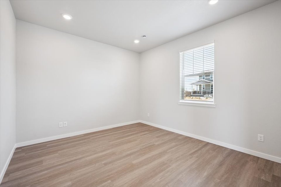 A room with a wood floor and a window.