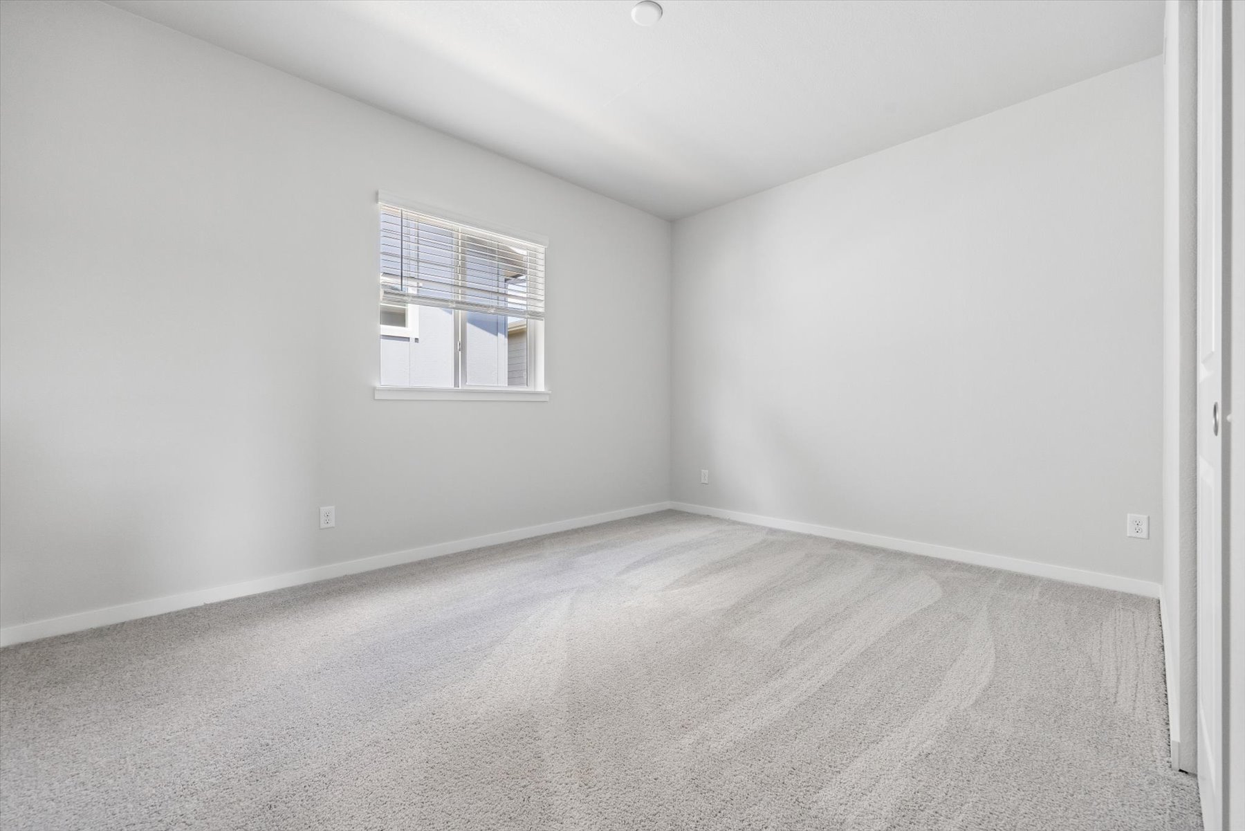 A room with a window and a carpet.