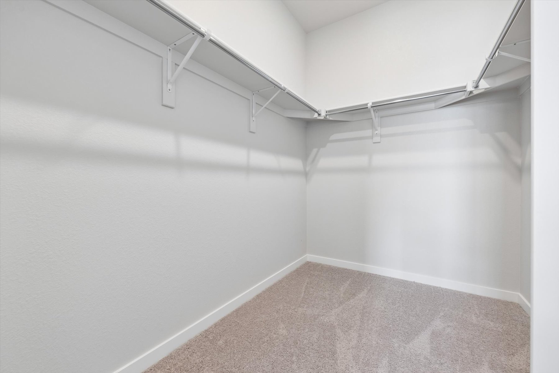 A white hallway with a metal railing.