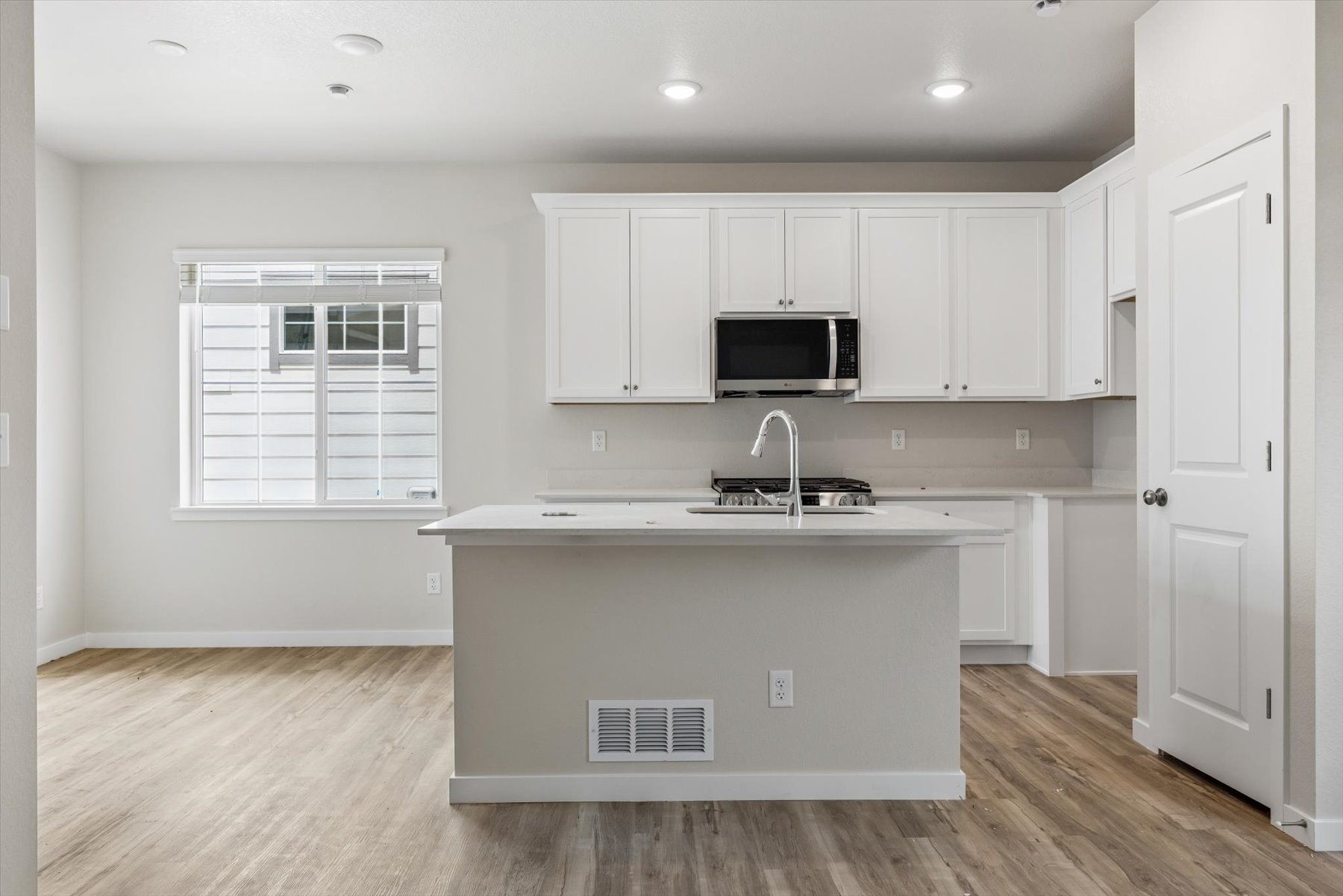 A kitchen with white cabinets.