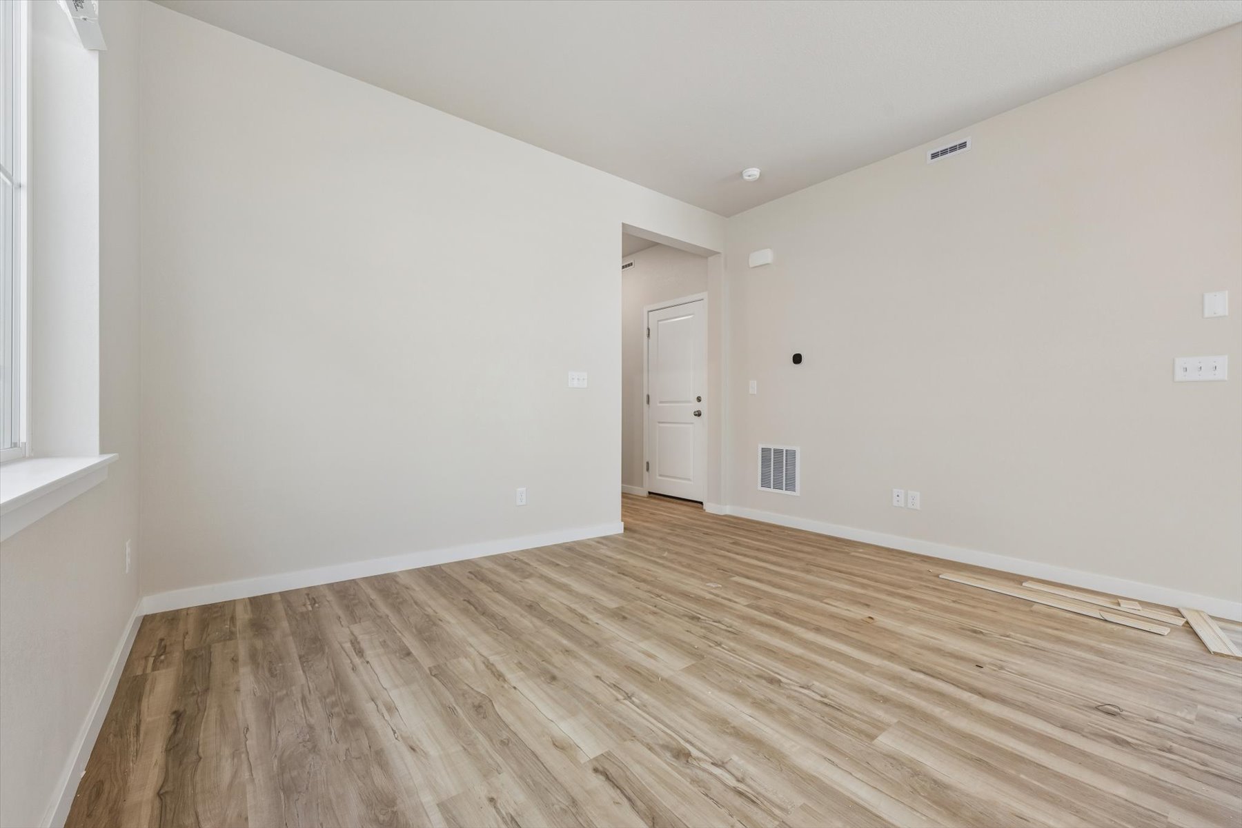 A room with a wood floor and a white door.