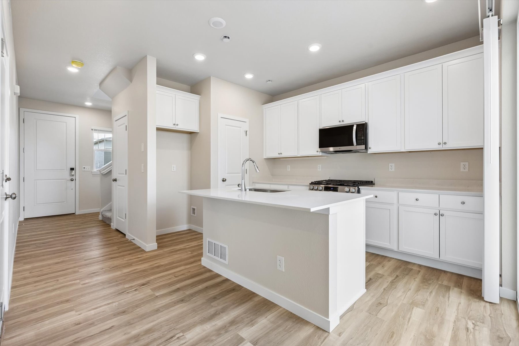 A kitchen with white cabinets.