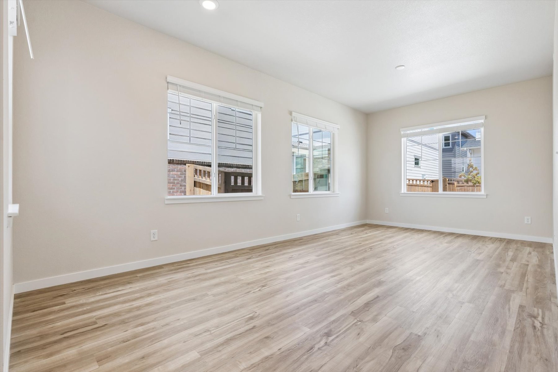 A room with a wood floor and windows.