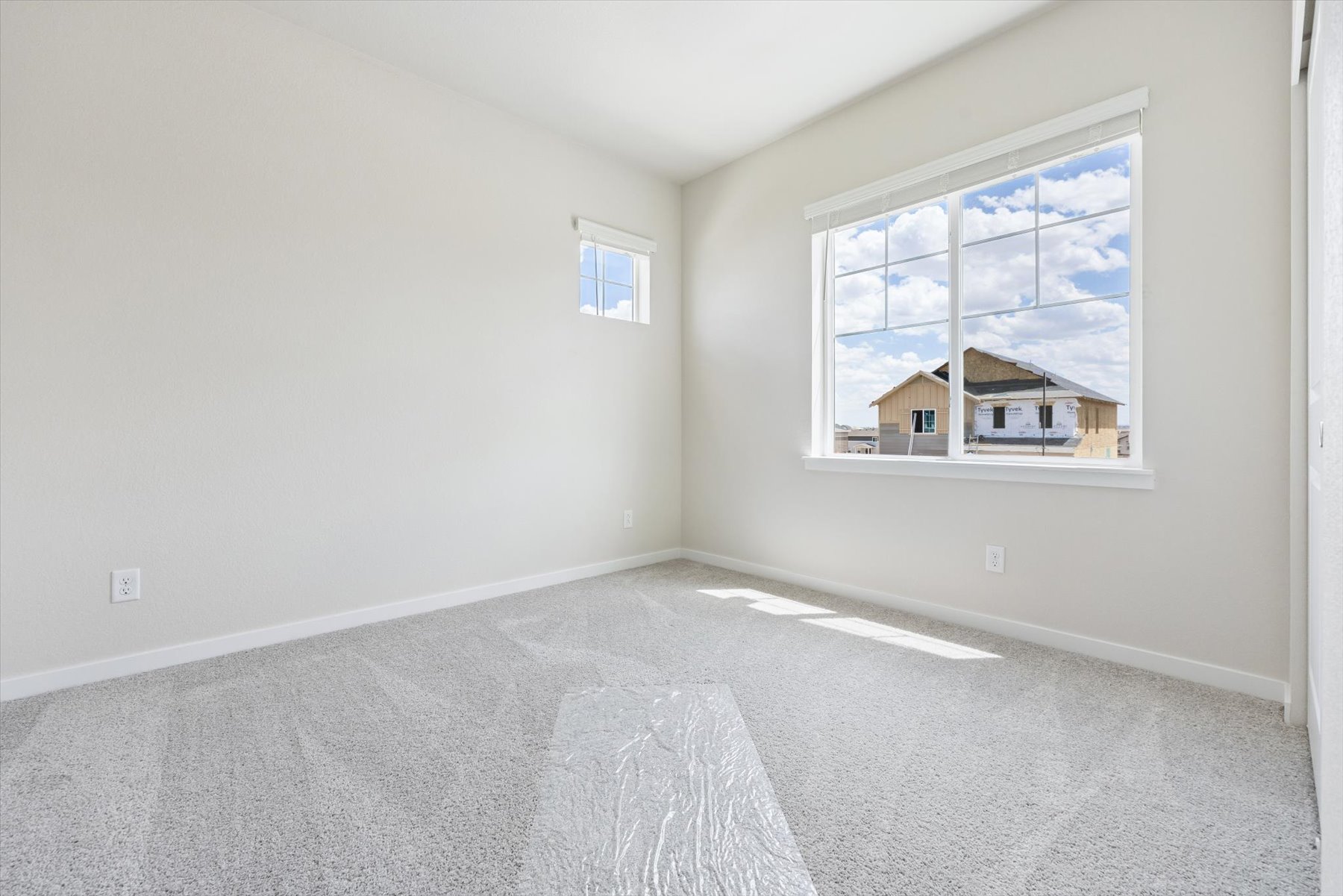 A room with a window and a rug.