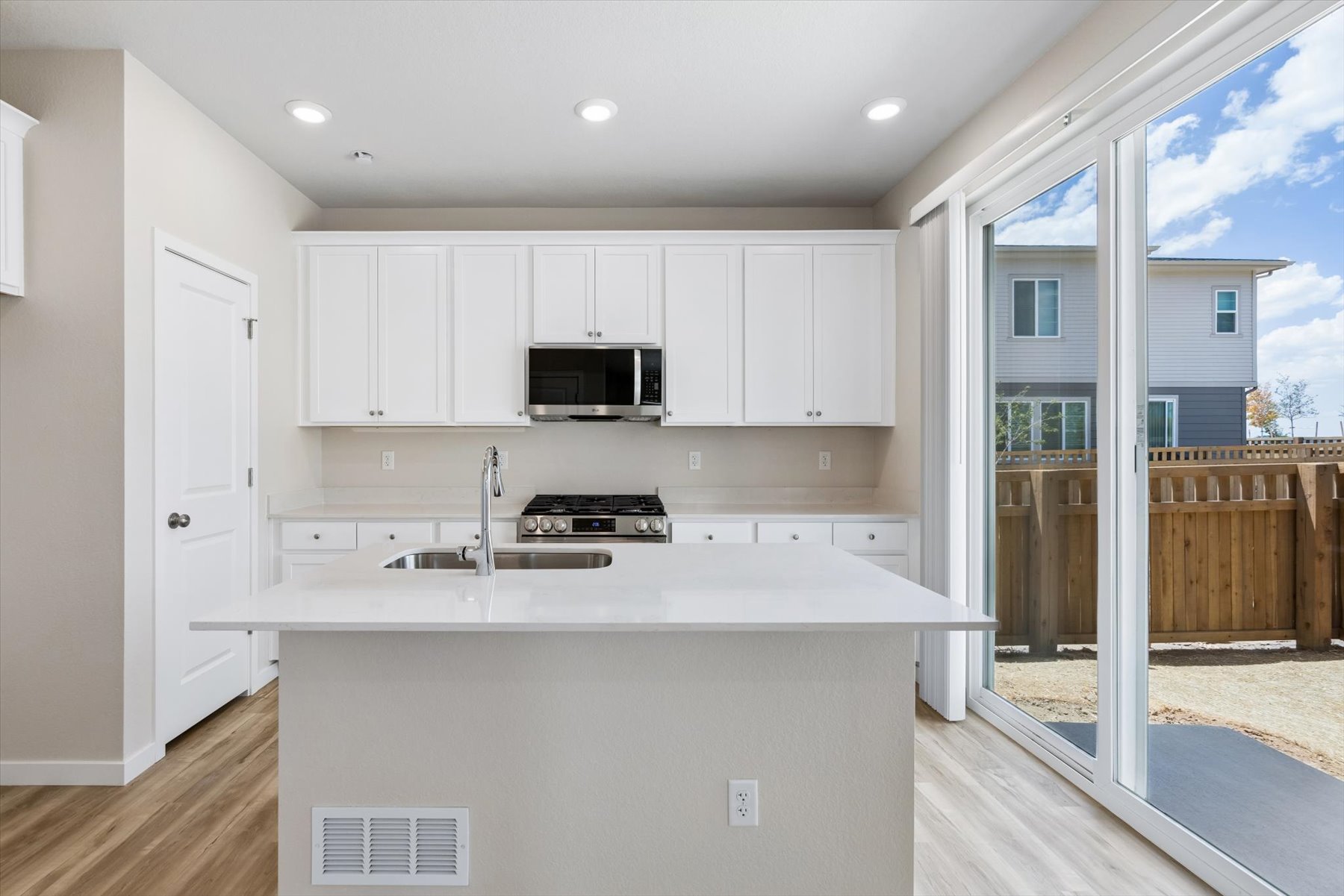 A kitchen with white cabinets.