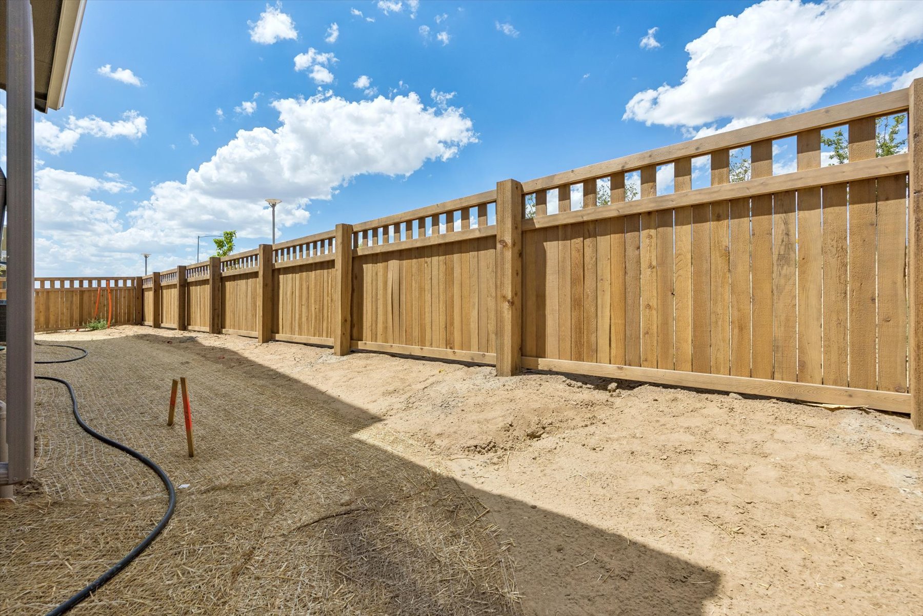 A wooden fence in a dirt area.