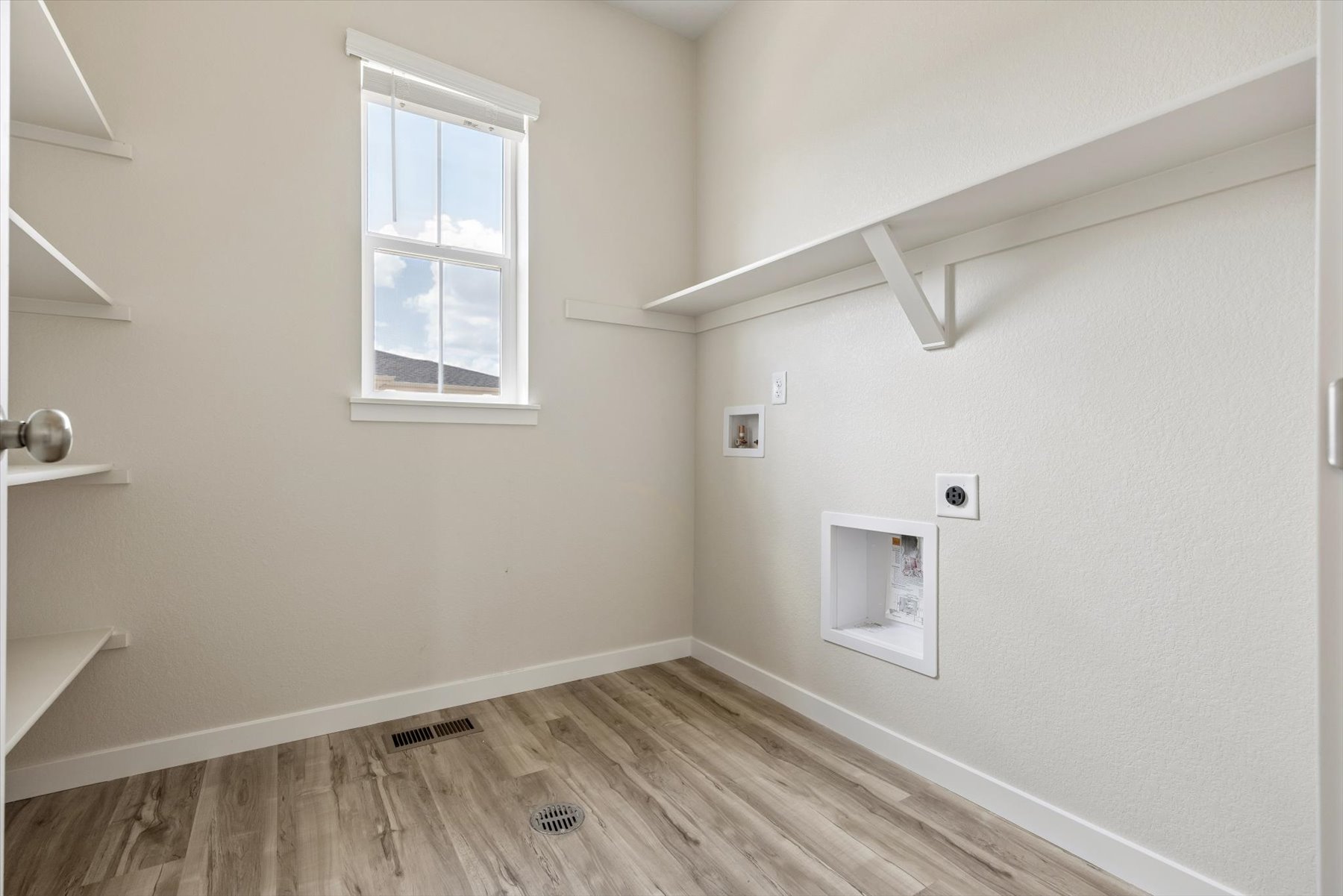A room with a window and a wood floor.