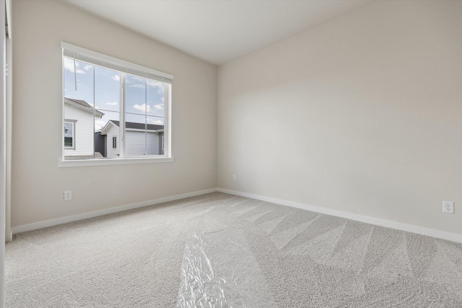 A room with a window and a carpet.