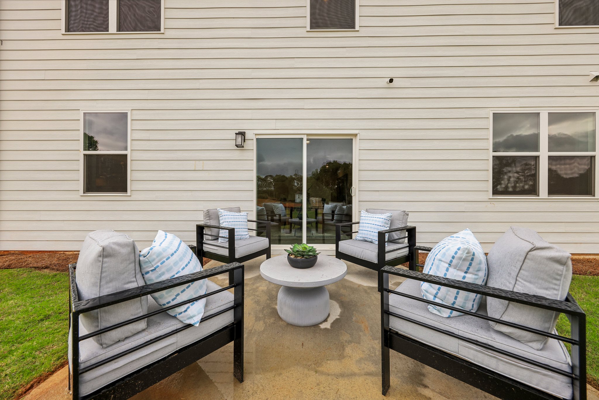 A backyard with a bench and a table and chairs.