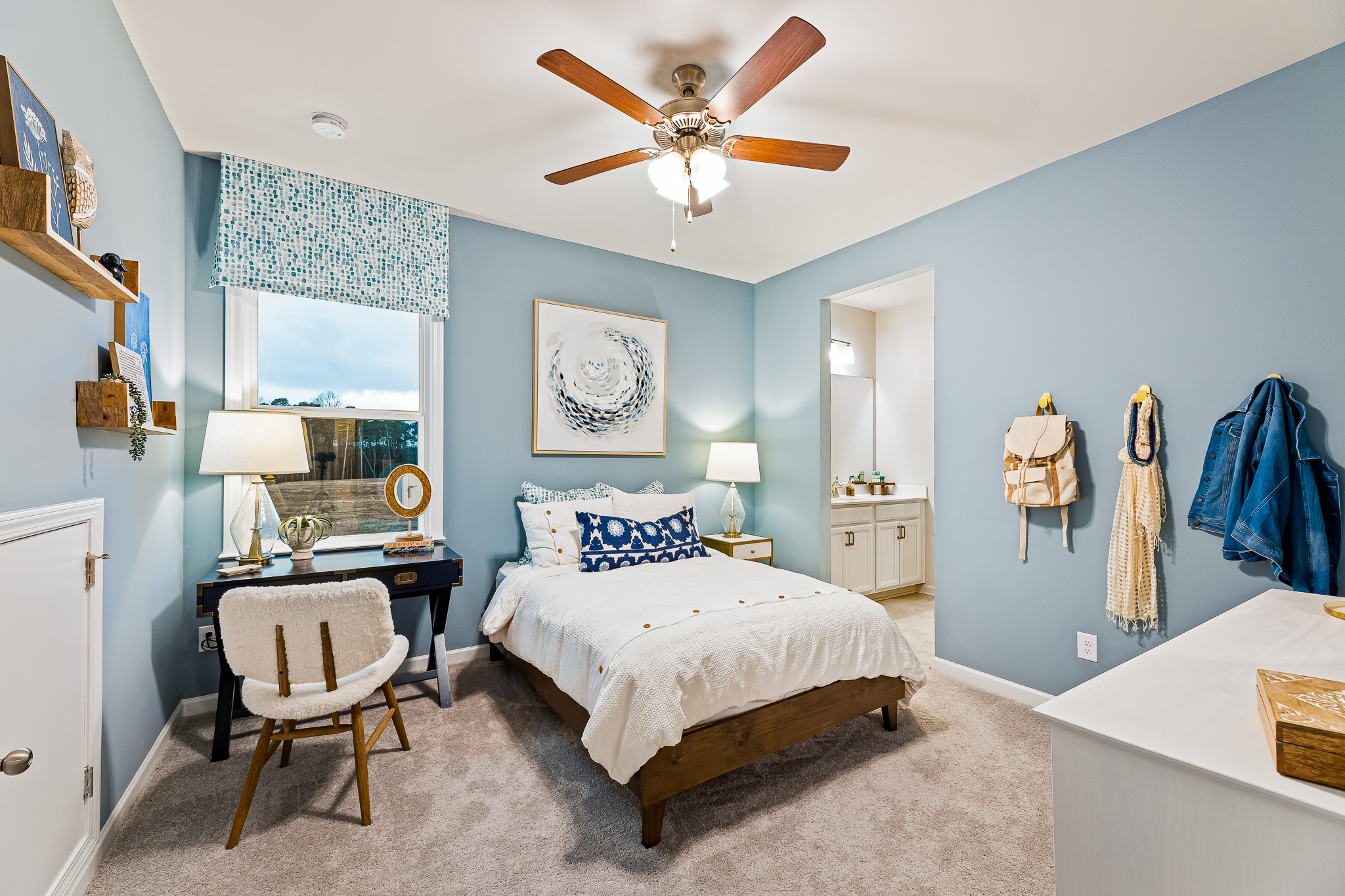 A bedroom with a bed and a fan.