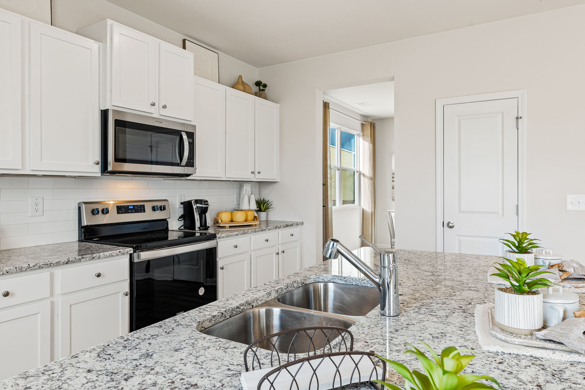 A kitchen with white cabinets.