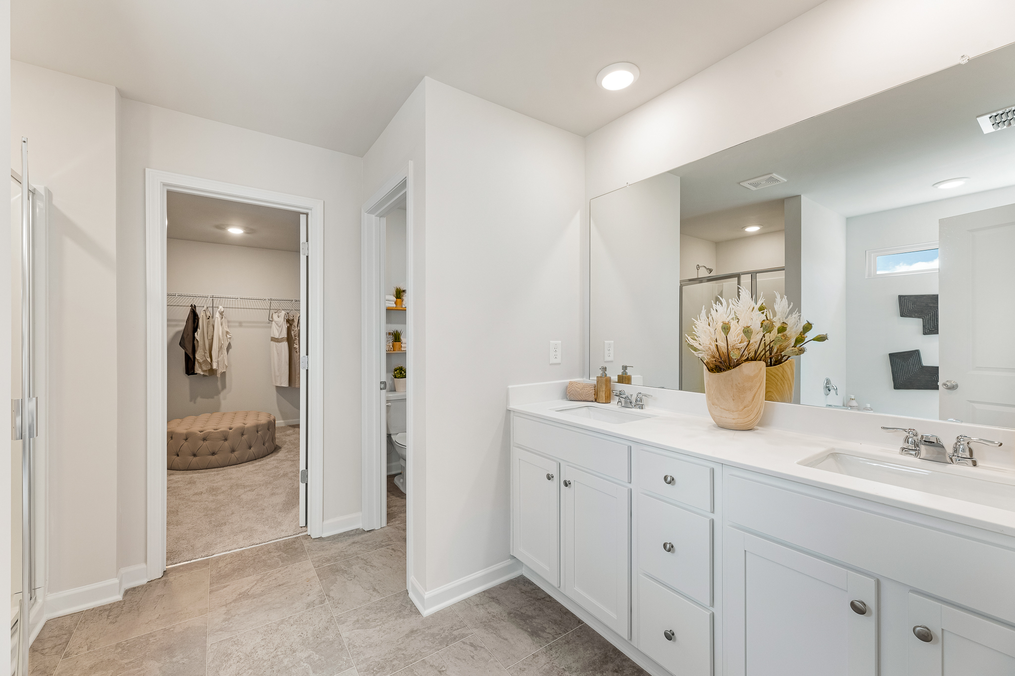 A bathroom with white cabinets.