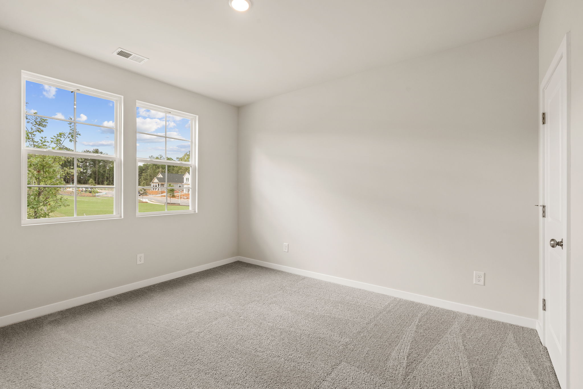 A room with a window and a carpet.