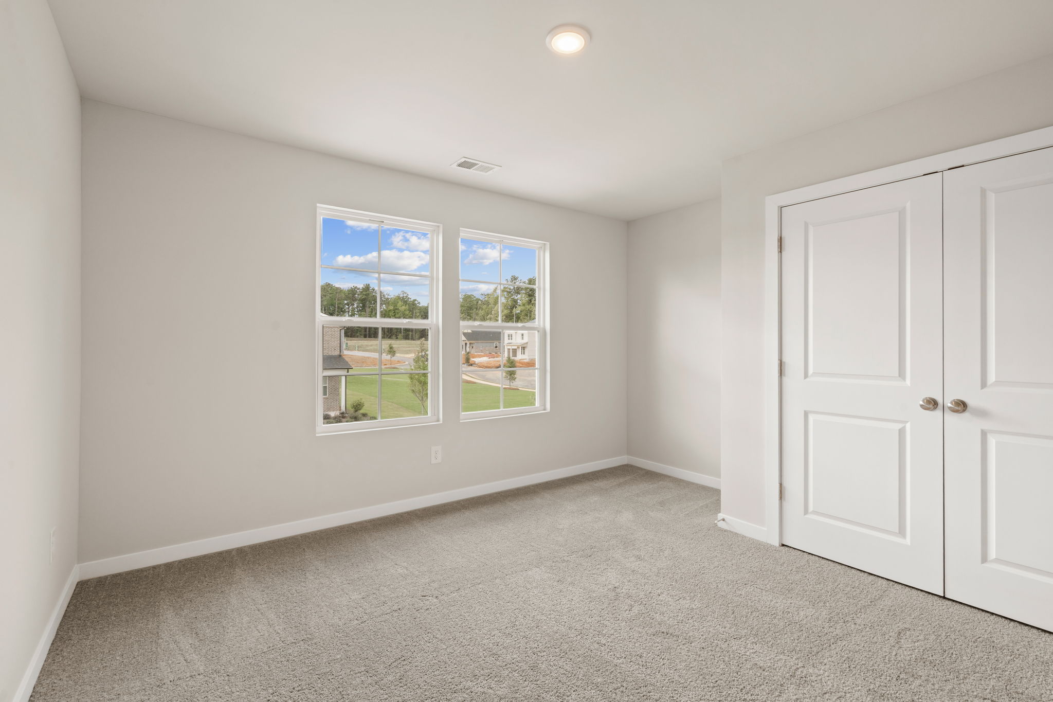 A room with white doors and a window.