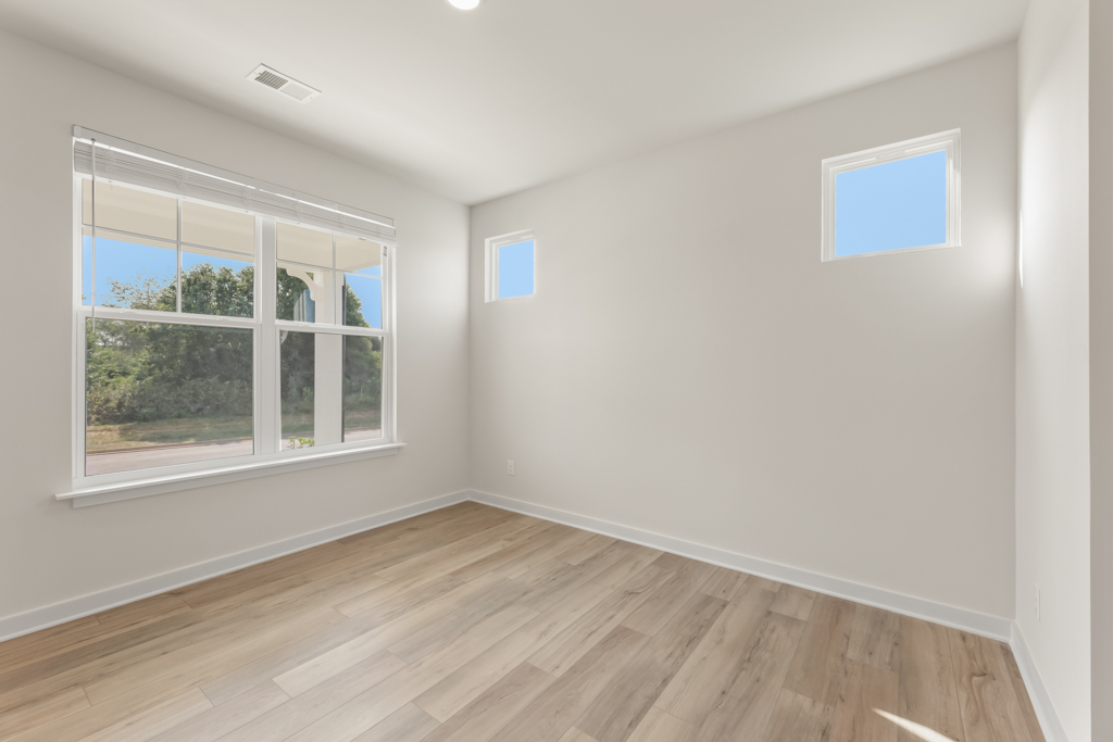 A room with a wood floor and windows.