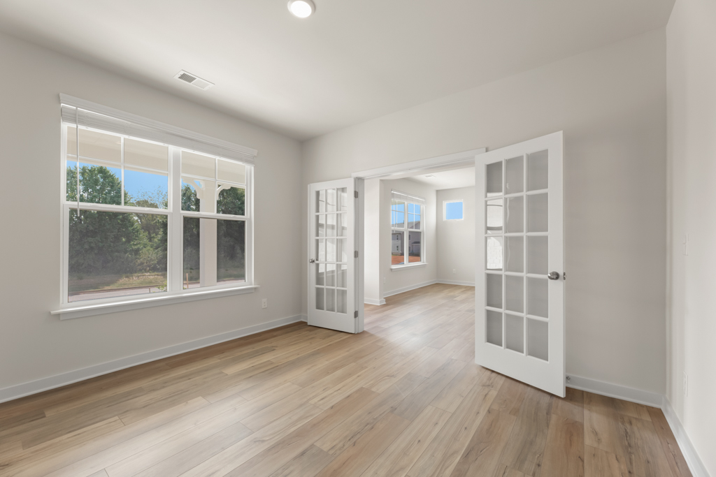 A room with a wood floor and a white door.