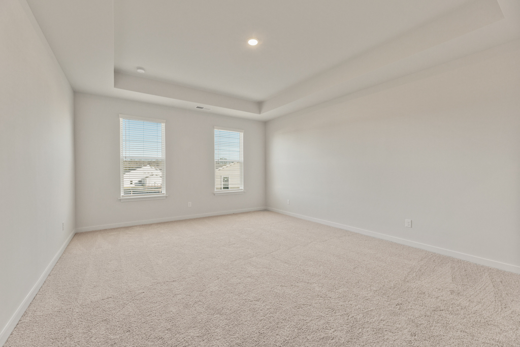 A room with a carpet and a window.