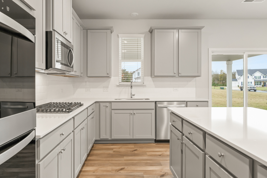 A kitchen with white cabinets.