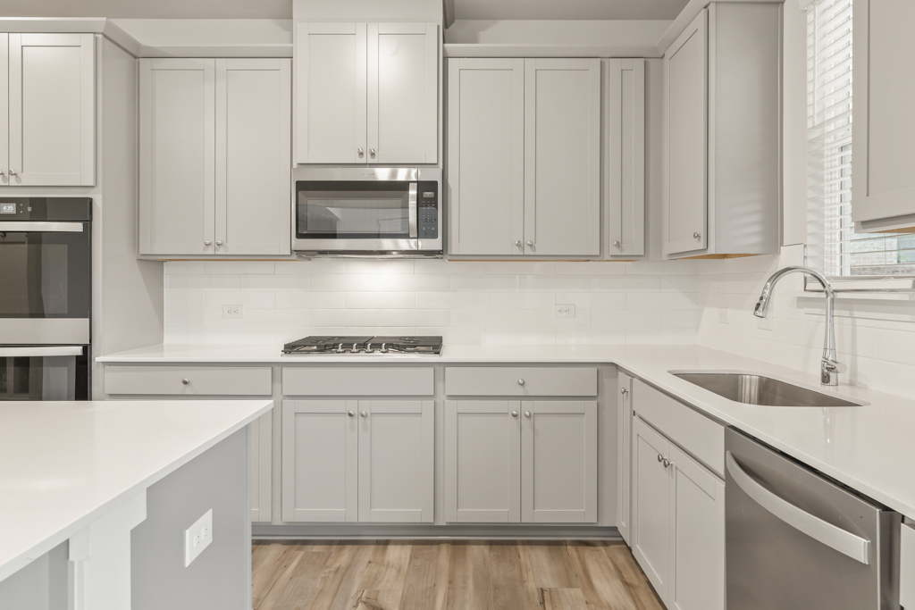 A kitchen with white cabinets.