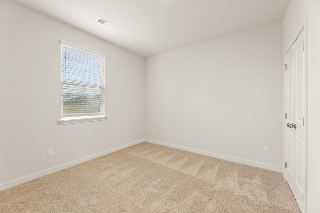 A room with a carpet and a door.