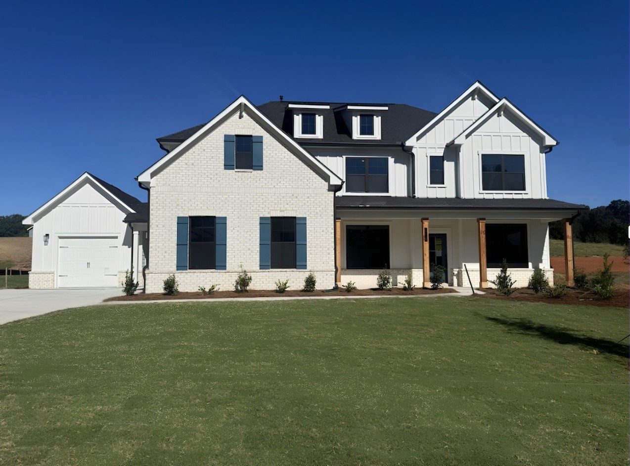A house with a lawn in front with Southfork Ranch in the background.