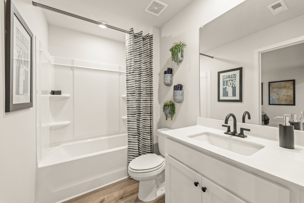 A bathroom with a tub sink and toilet.