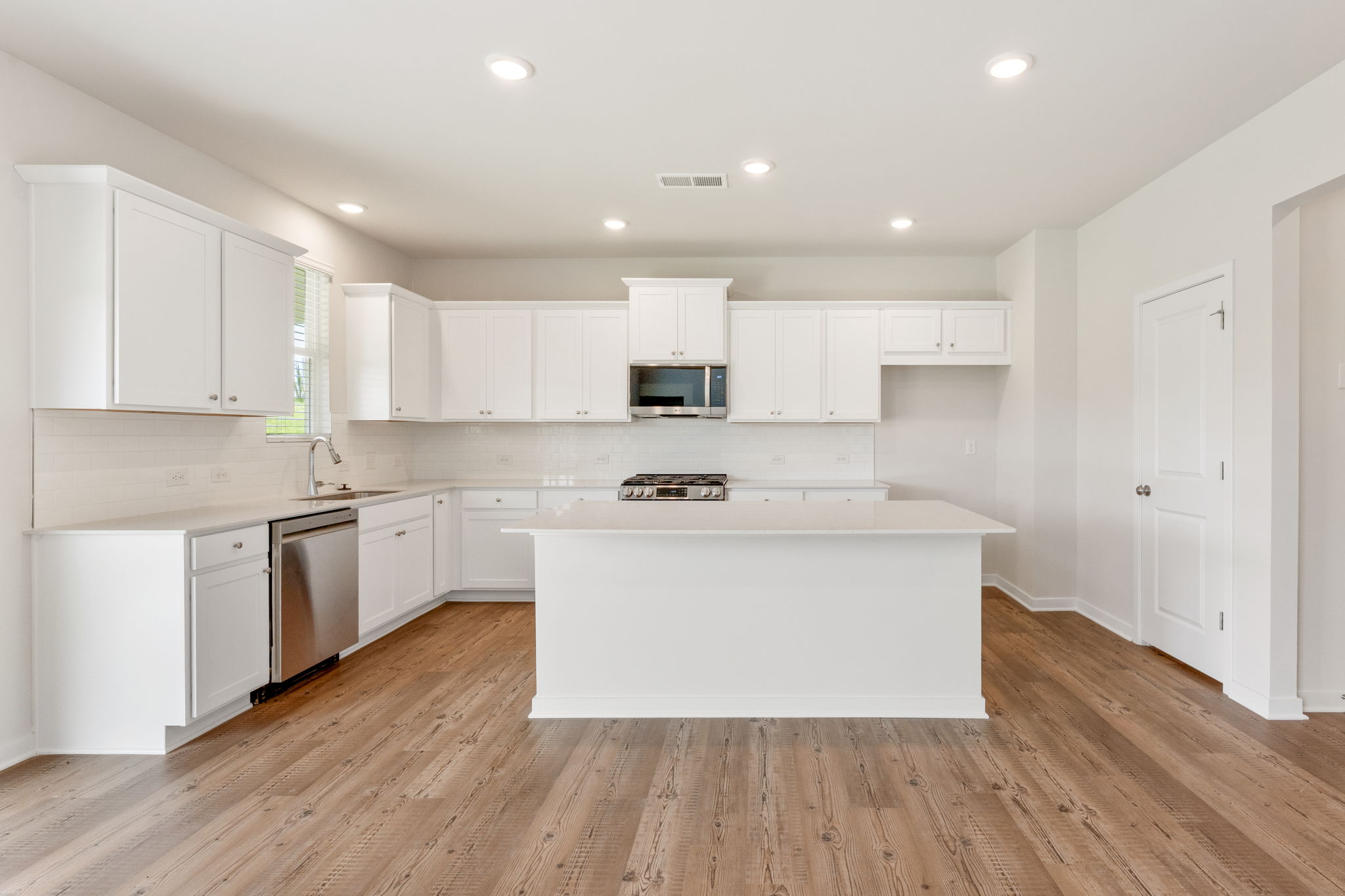 A kitchen with white cabinets.