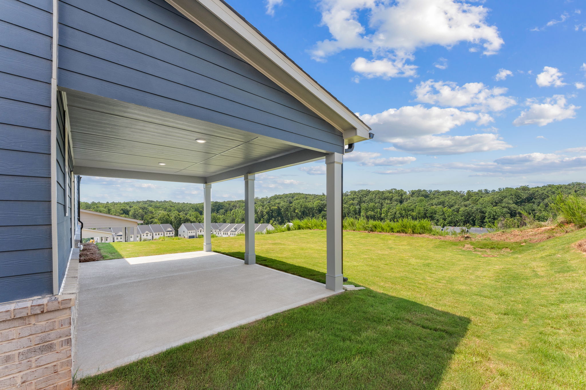 A covered walkway with grass and trees.