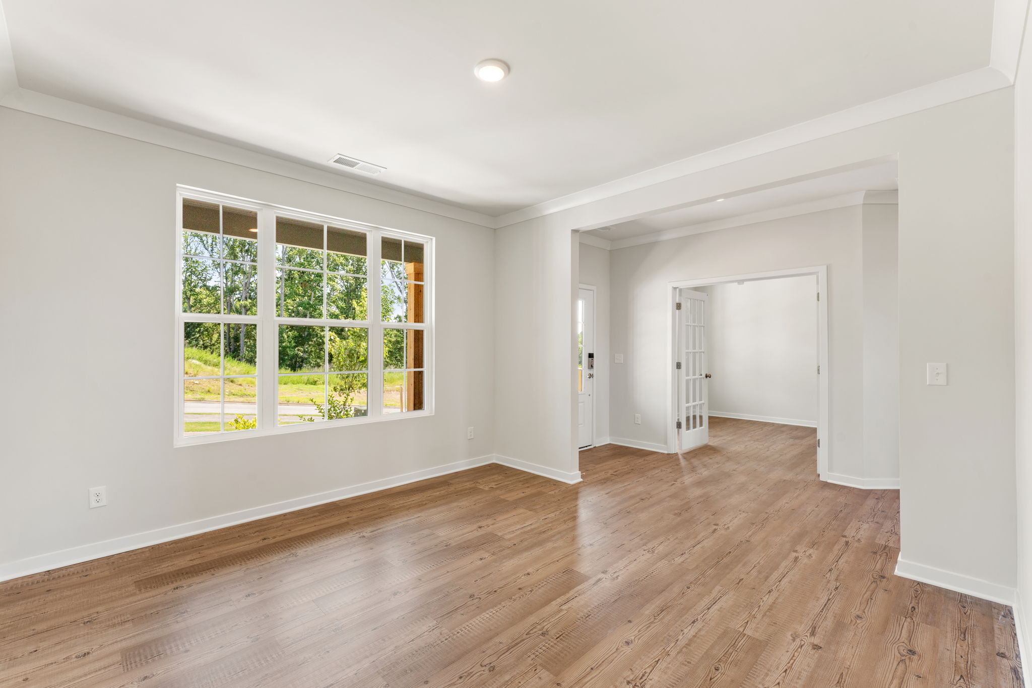 A room with a wood floor and a window.