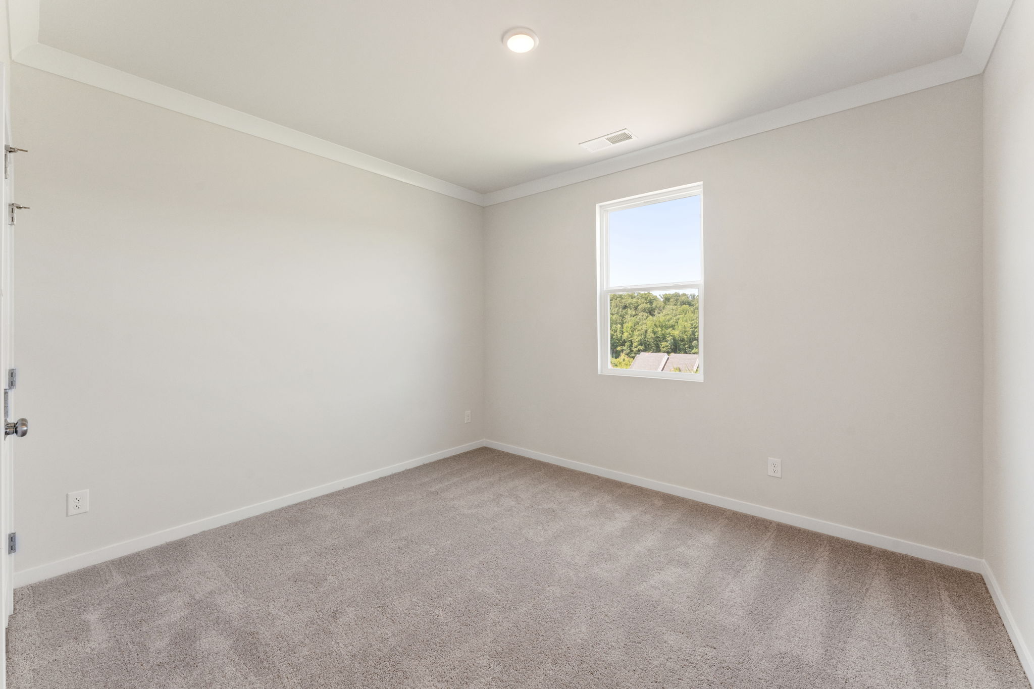 A room with a window and a carpet.