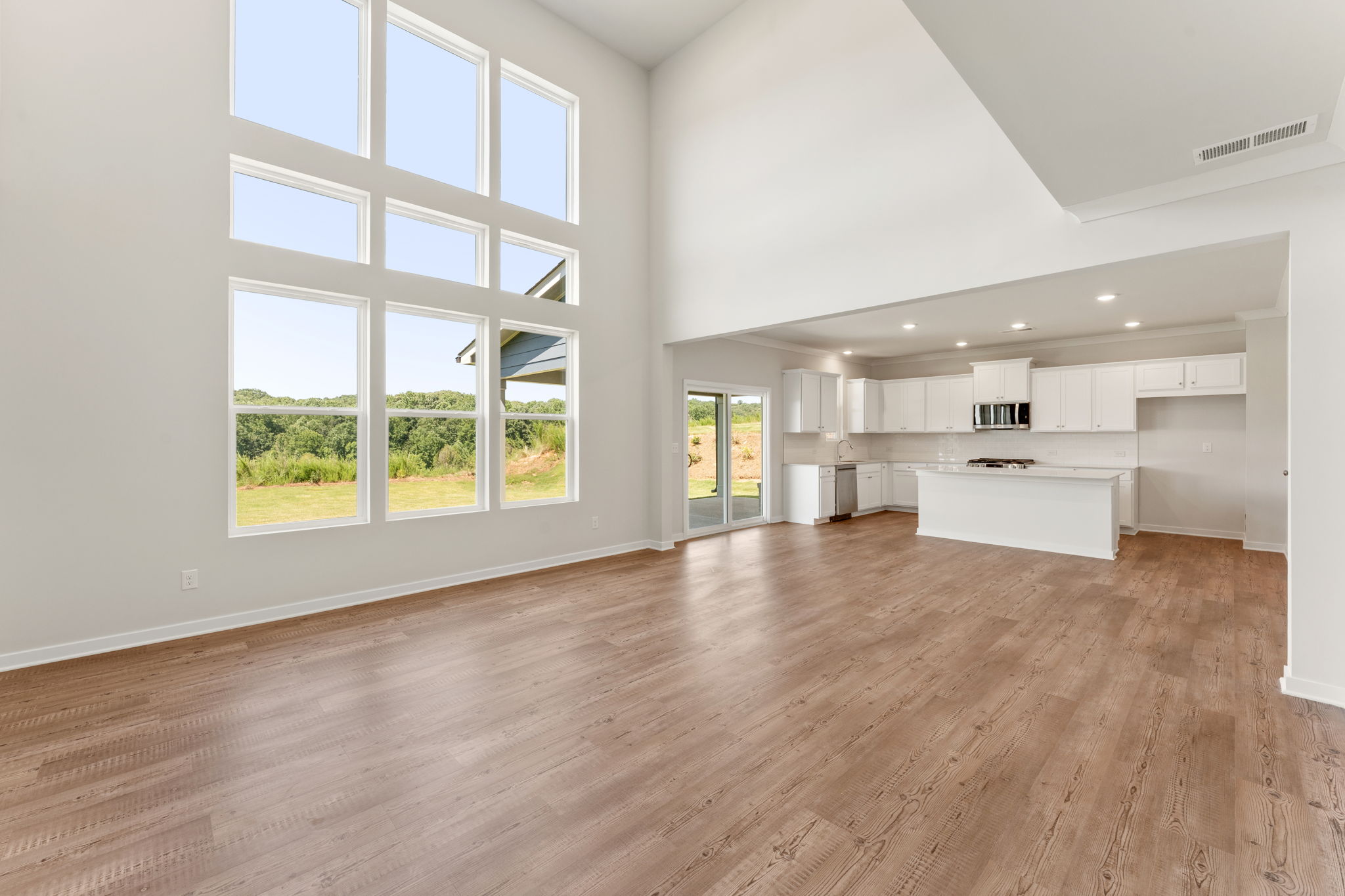 A large empty room with a wood floor and windows.