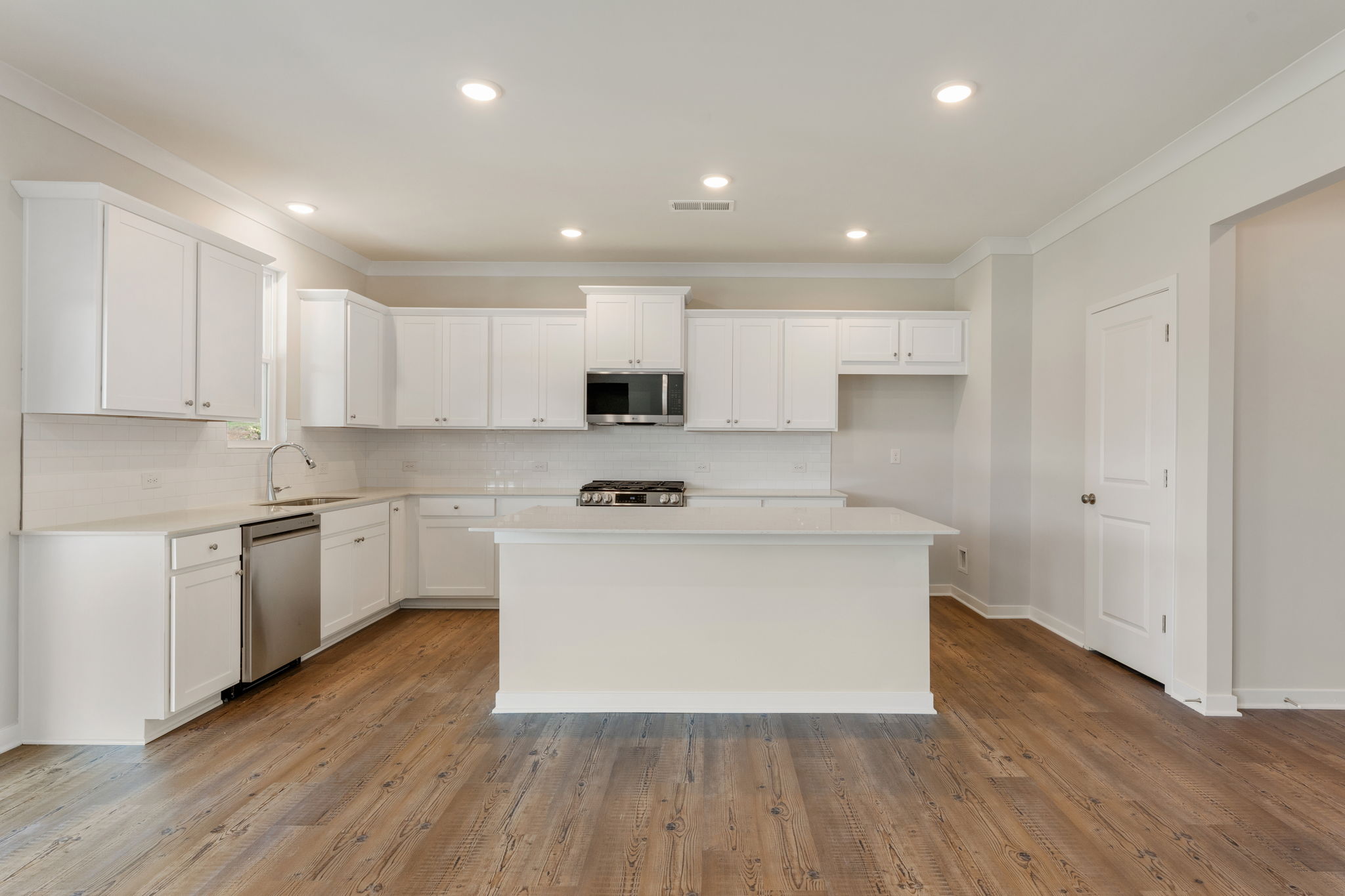 A kitchen with white cabinets.