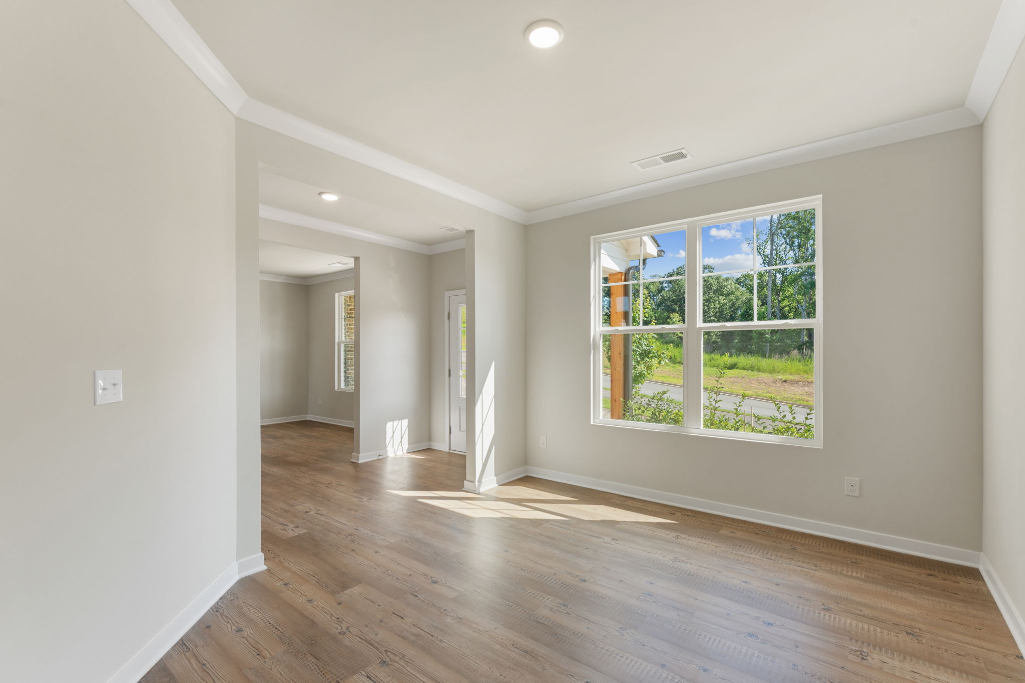 A room with a wood floor and a window with a wood floor.