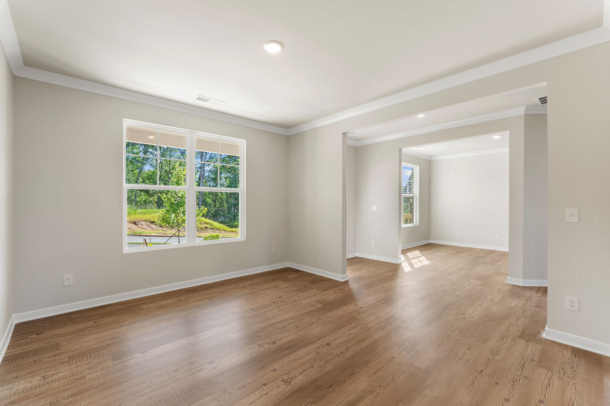 A room with a wood floor and a wood floor with a window.