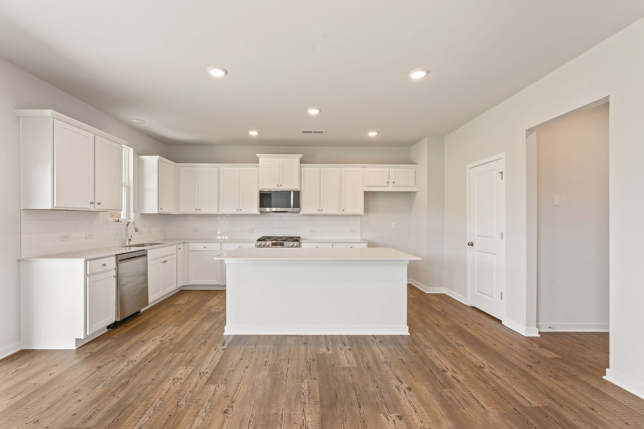 A kitchen with white cabinets.