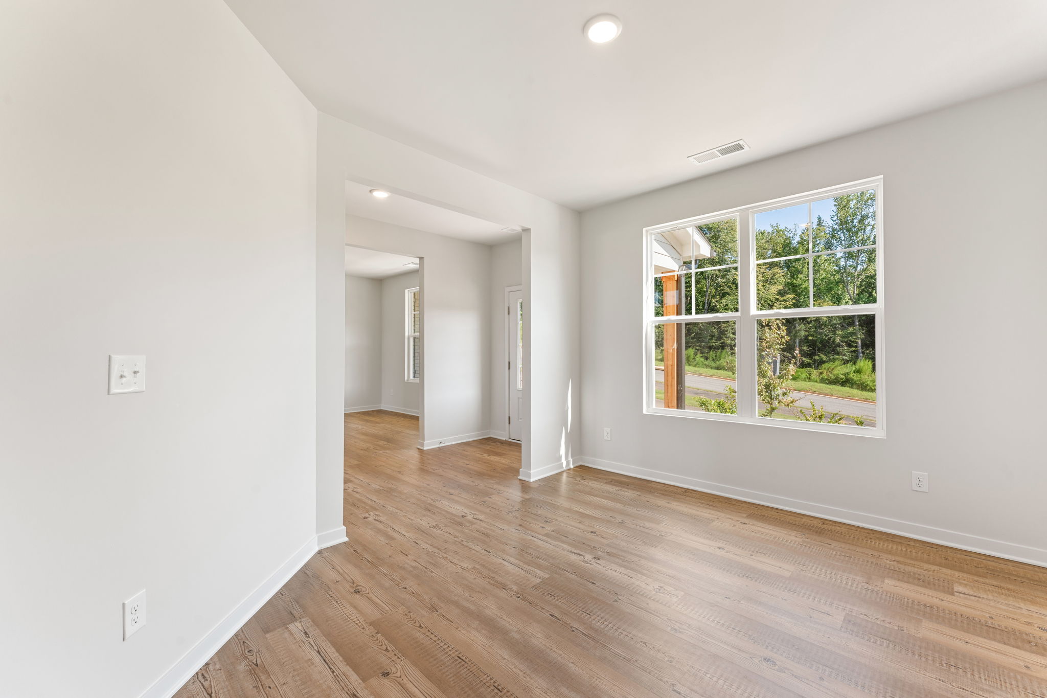 A room with a wood floor and a window.