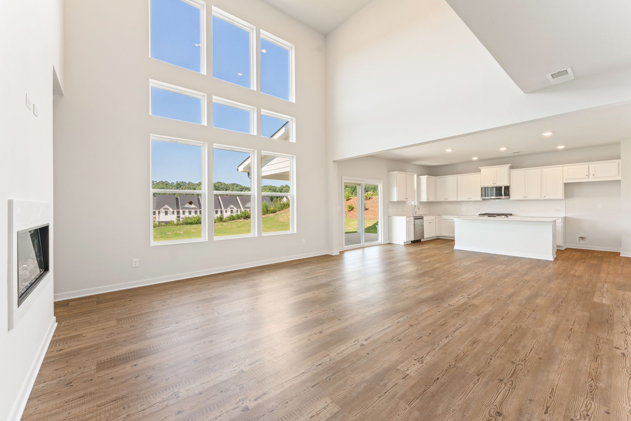 A large empty room with a wood floor and a large window.