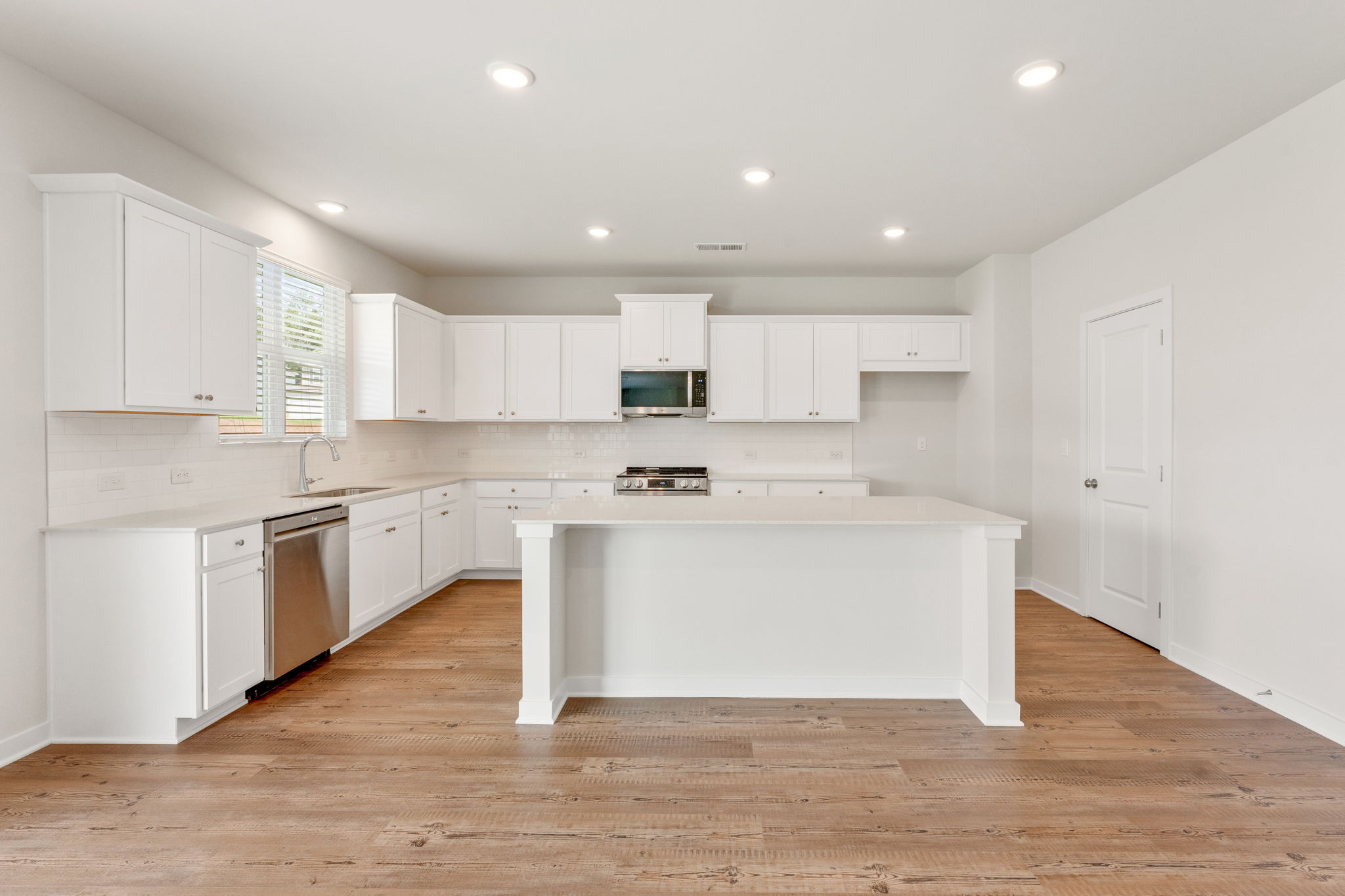 A kitchen with white cabinets.