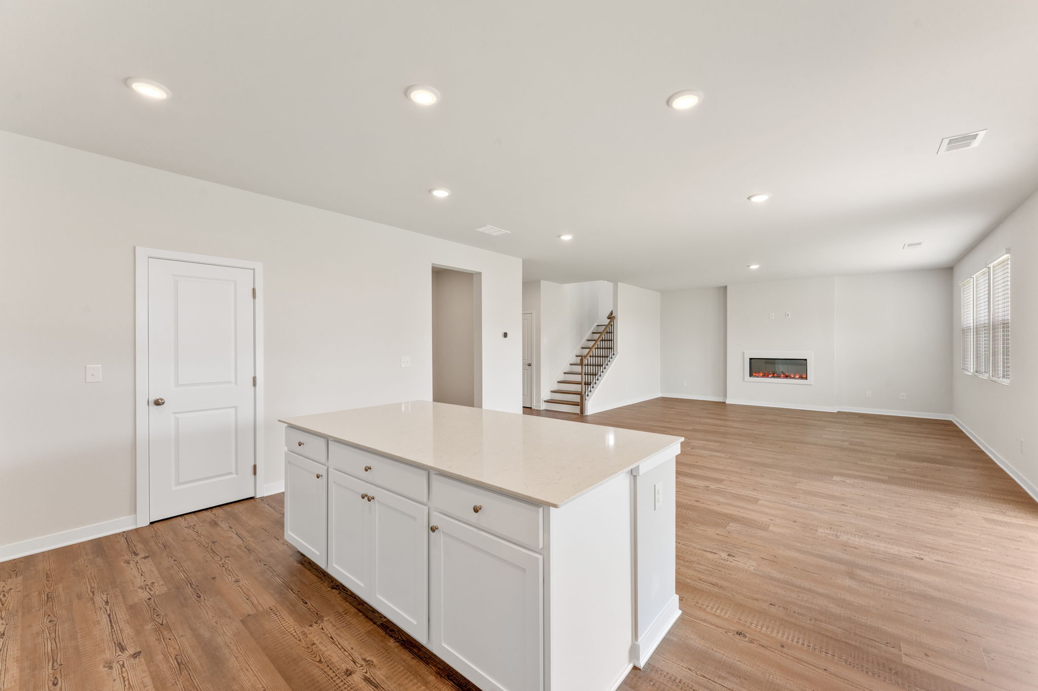A large empty room with white cabinets.