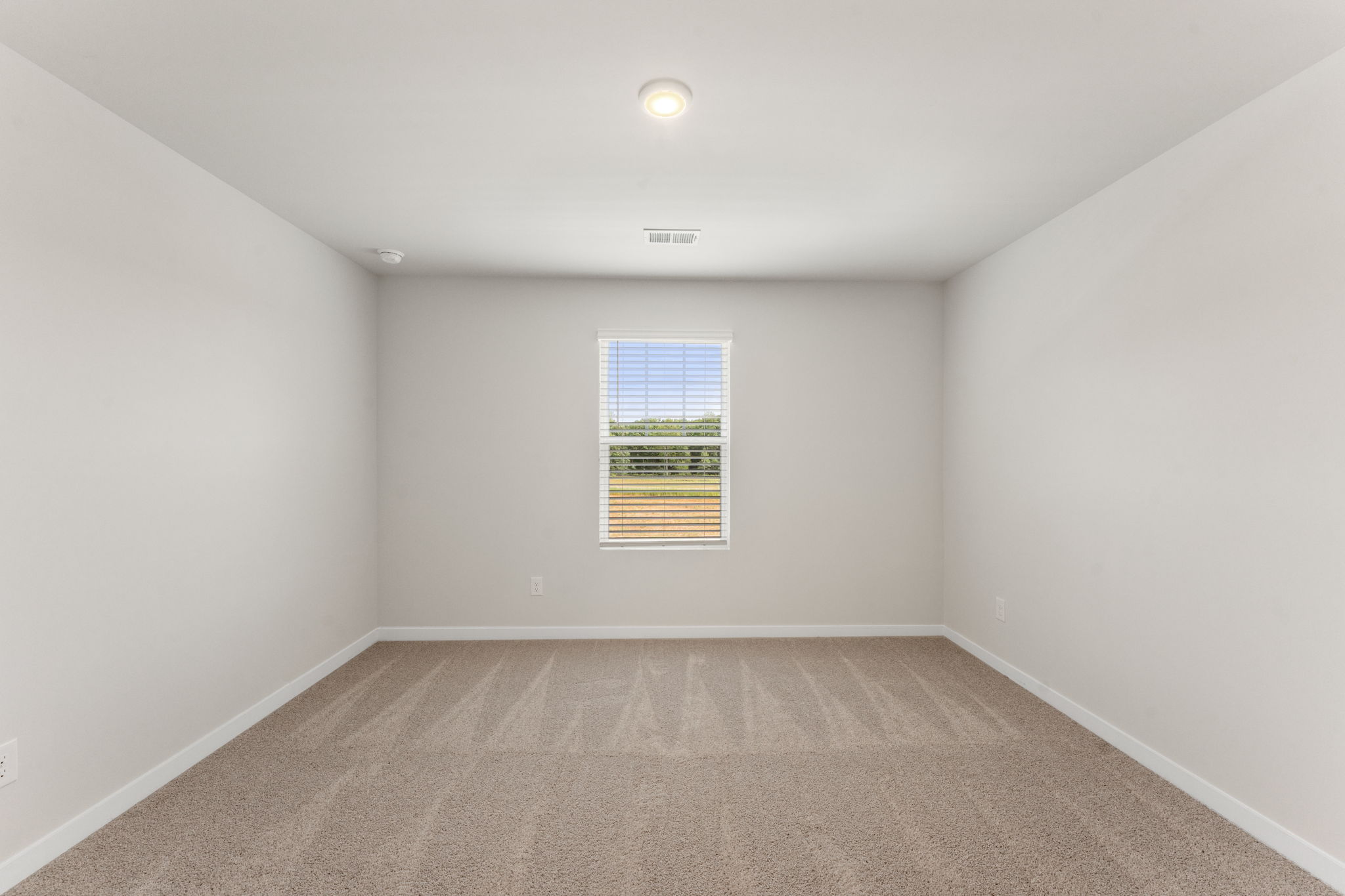 A room with a window and a carpet.