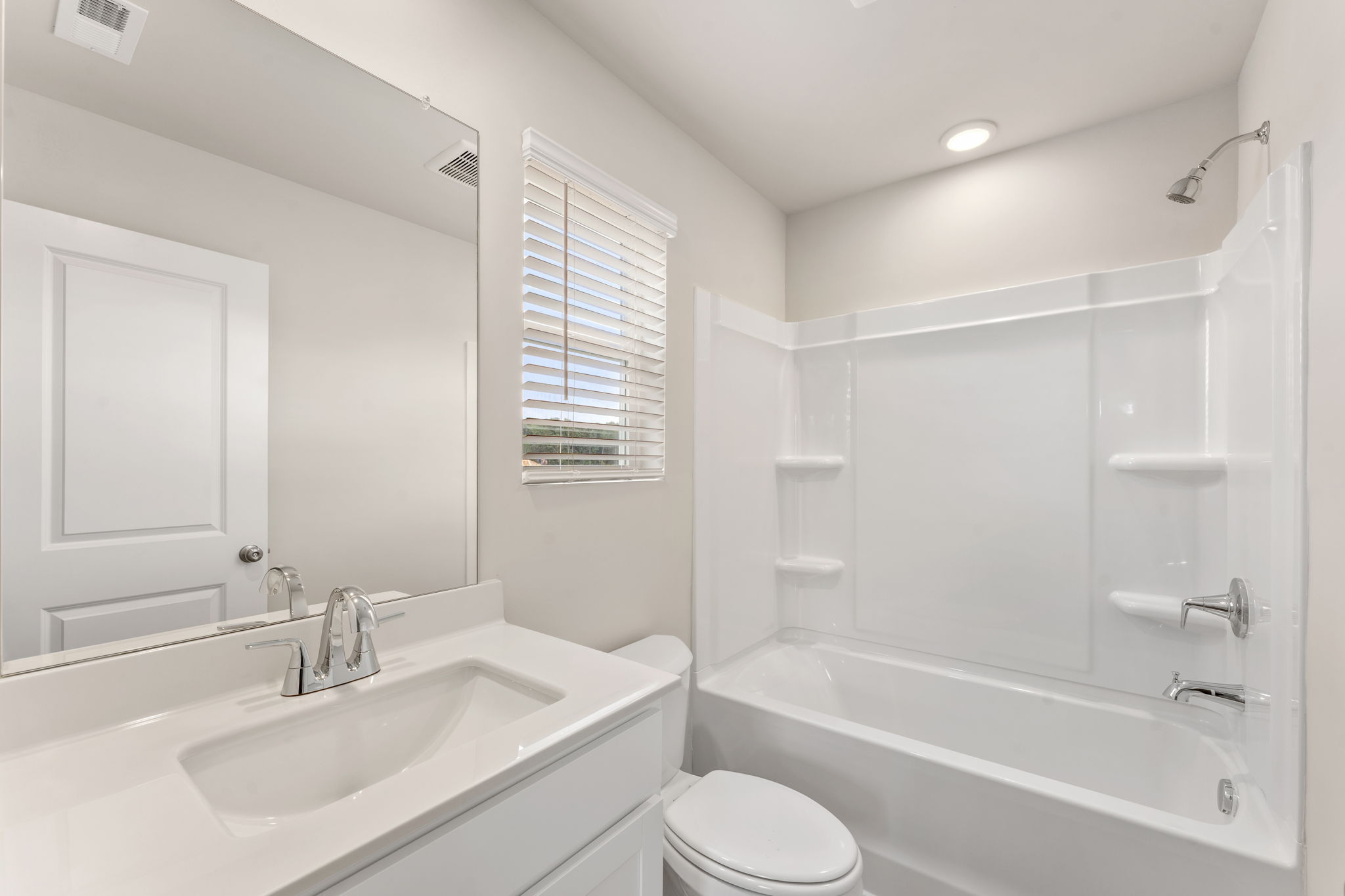 A bathroom with a tub sink and toilet.