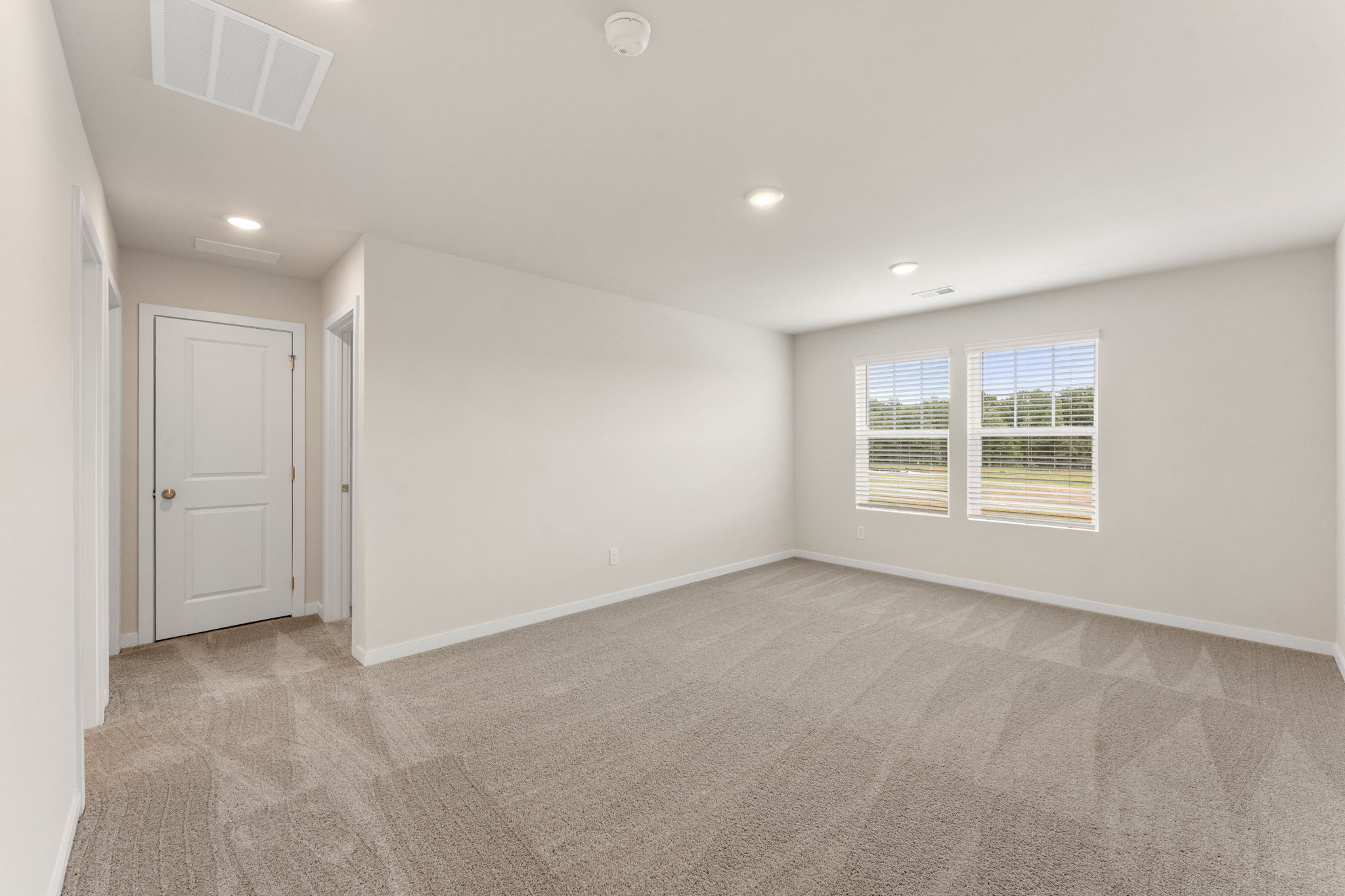 A room with a carpet and a door.