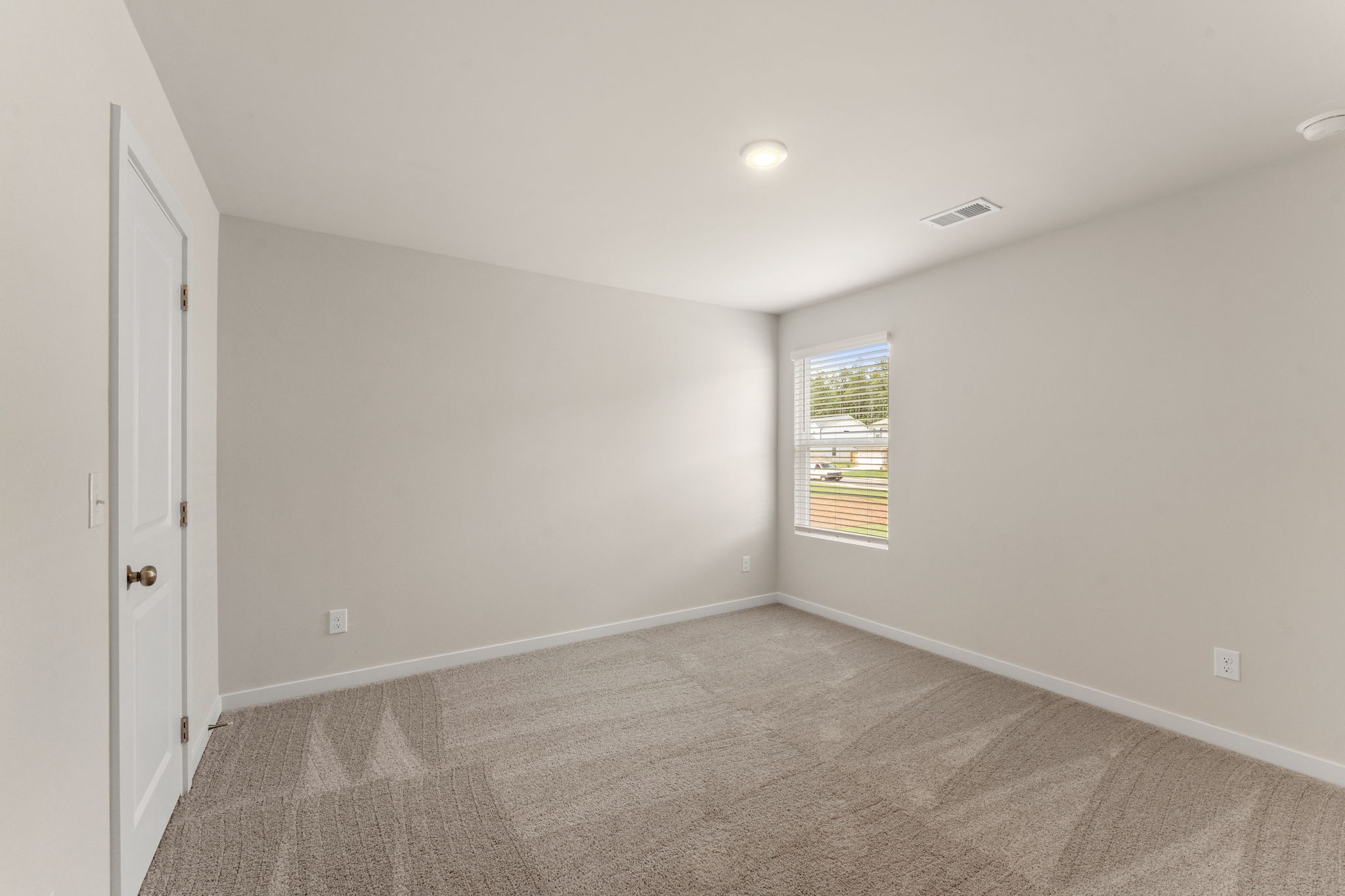 A room with a carpet and a window.